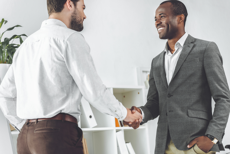 Two men shaking hands; the title is 3 top tactics to engage your sorority or fraternity's alumni